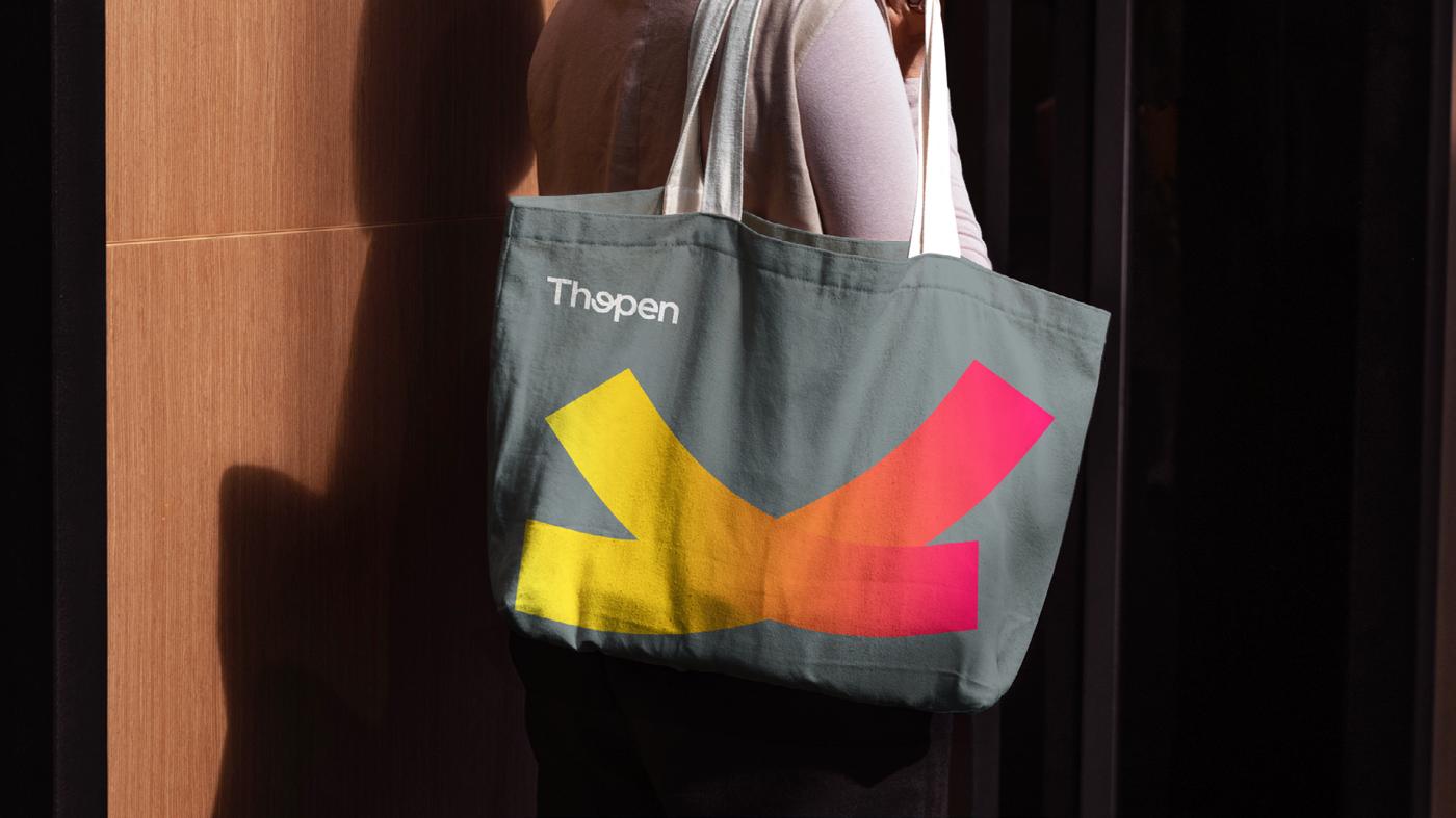 Ecobag cinza com a marca e o fragmento do símbolo